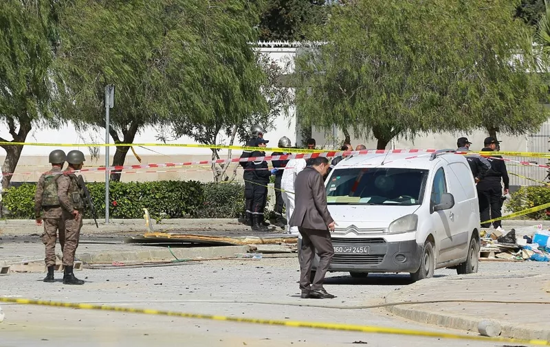 Police and forensic experts inspect the scene of an explosion near the US embassy in the Tunisian capital Tunis on March 6, 2020. - A double suicide attack shook the Tunisian capital as assailants wounded six people including police guarding the US embassy, authorities said. An explosion rocked the Berges du Lac district where the embassy is located around midday, causing panic among pedestrians and motorists in the area. Two assailants died in the attack, the first to hit the capital since June 2019, according to officials. (Photo by Anis MILI / AFP)
