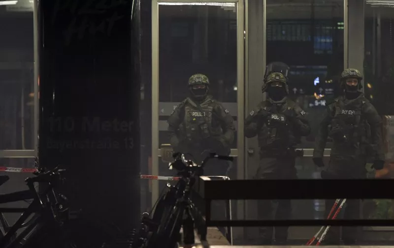 Police officers in riot gear are seen guarding the entrance to the closed central station in Munich on January 1, 2016. 
German police said Thursday that they had "indications that a terror attack" was being planned for New Year's Eve in the southern city of Munich, as they called on the public to avoid large gatherings and two key train stations. / AFP / Christof STACHE