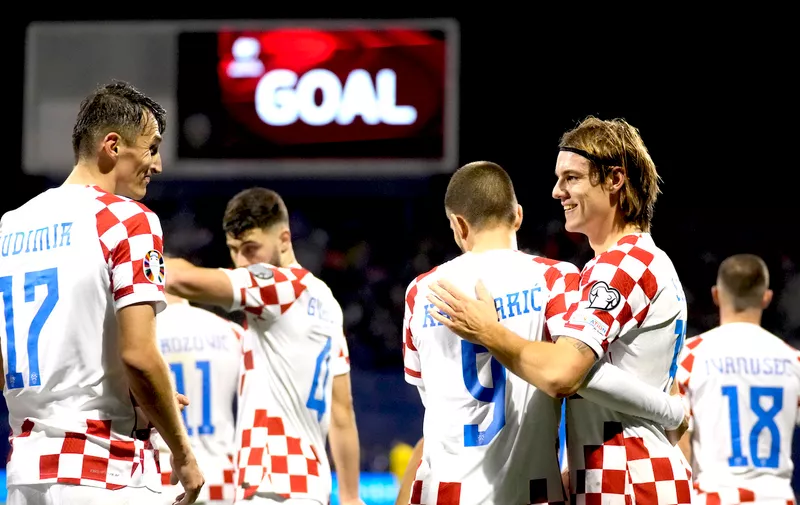 Croatia's Ante Budimir, left, celebrates with his teammates after scoring against Armenia during the Euro 2024 group D qualifying soccer match between Croatia and Armenia at the Maksimir Stadium in Zagreb, Croatia, Tuesday, Nov. 21, 2023. (AP Photo/Darko Bandic)