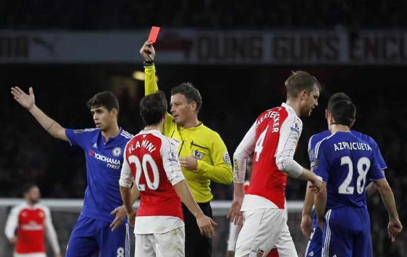 Referee Mark Clattenburg (C) shows a red card to Arsenal's German defender Per Mertesacker (2nd R) after his challenge on Diego Costa (not pictured) during the English Premier League football match between Arsenal and Chelsea at the Emirates Stadium in London on January 24, 2016. AFP PHOTO / IKIMAGES

RESTRICTED TO EDITORIAL USE. No use with unauthorized audio, video, data, fixture lists, club/league logos or 'live' services. Online in-match use limited to 75 images, no video emulation. No use in betting, games or single club/league/player publications. / AFP / IKIMAGES