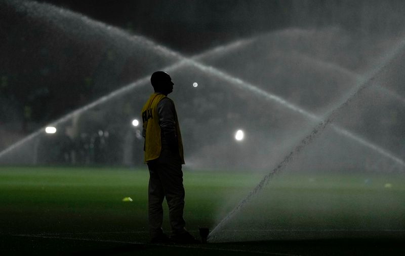 A field worker waters the pitch prior to the World Cup group E soccer match between Costa Rica and Germany at the Al Bayt Stadium in Al Khor , Qatar, Thursday, Dec. 1, 2022. (AP Photo/Hassan Ammar)