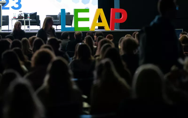 Publika sluša predavanje na konferenciji s velikim šarenim natpisom LEAP na pozornici.