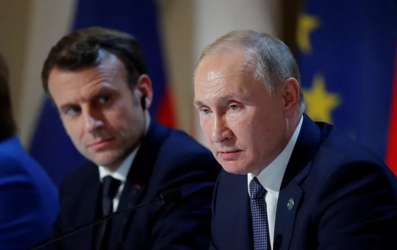 French President Emmanuel Macron (L) and Russian President Vladimir Putin (R) give a press conference after a summit on Ukraine at the Elysee Palace, in Paris, on December 9, 2019. - Leaders aim for new withdrawal of forces from Ukraine conflict zones by March 2020, according to a communique on December 9, 2019. (Photo by CHARLES PLATIAU / POOL / AFP)