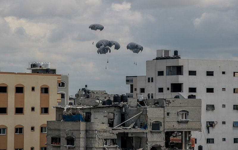 Humanitarian aid parcels attached to parachutes are airdropped from a military aircraft over the Gaza Strip on March 25, 2024, amid the ongoing conflict between Israel and the Palestinian Hamas movement. (Photo by AFP)