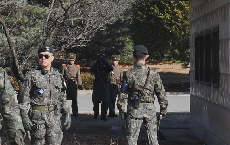 (FILES) This file photo taken on November 27, 2017 shows North Korean soldiers staring at South Korean soldiers at the truce village of Panmunjom in the Demilitarized zone (DMZ) dividing the two Koreas.
A North Korean soldier defected to the South on December 21, 2017 across the Demilitarized Zone that divides the peninsula, Seoul's defence ministry said. It came a month after a rare and dramatic defection by a soldier at Panmunjom, the truce village where opposing forces confront each other across a concrete dividing line. / AFP PHOTO / KOREA POOL / - / South Korea OUT