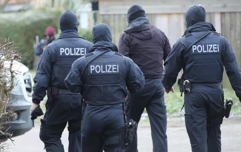 Policemen walk near a house in Meldorf, northern Germany during an operation on January 30, 2019. - German police commandos arrested three Iraqis suspected of planning an Islamist attack using explosives, a gun and a vehicle. (Photo by Bodo Marks / dpa / AFP) / Germany OUT