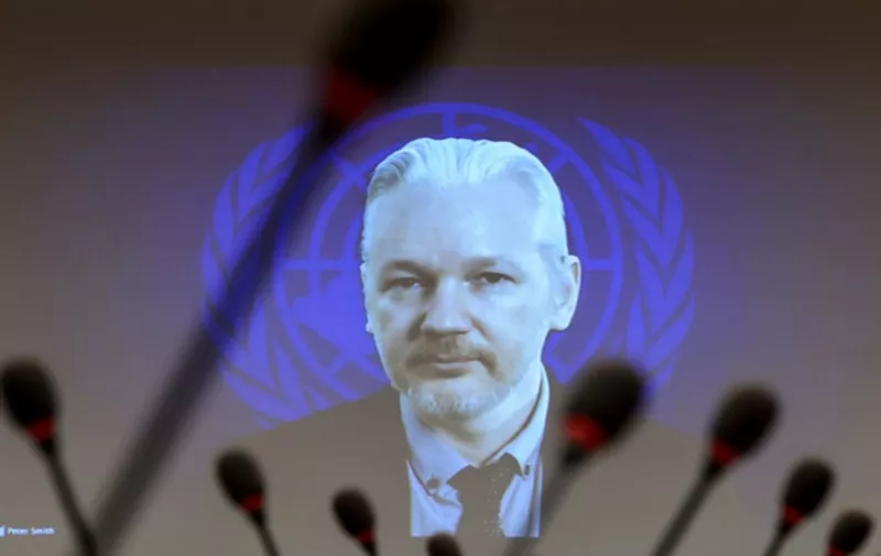 WikiLeaks founder Julian Assange is seen on a screen speaking via web cast from the Ecuadorian Embassy in London during an event on the sideline of the United Nations (UN) Human Rights Council session on March 23, 2015 in Geneva. Assange took refuge in June 2012 in the Ecuadorian Embassy to avoid extradition to Sweden, where he faces allegations of rape and sexual molestation, which he strongly denies.  AFP PHOTO / FABRICE COFFRINI