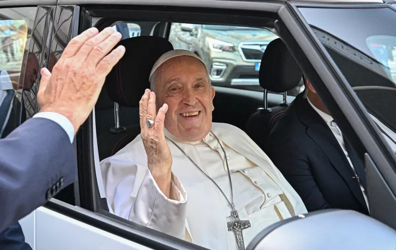Pope Francis waves as he leaves after being discharged from the Gemelli hospital in Rome on June 16, 2023, where he underwent abdominal surgery last week. (Photo by Alberto PIZZOLI / AFP)