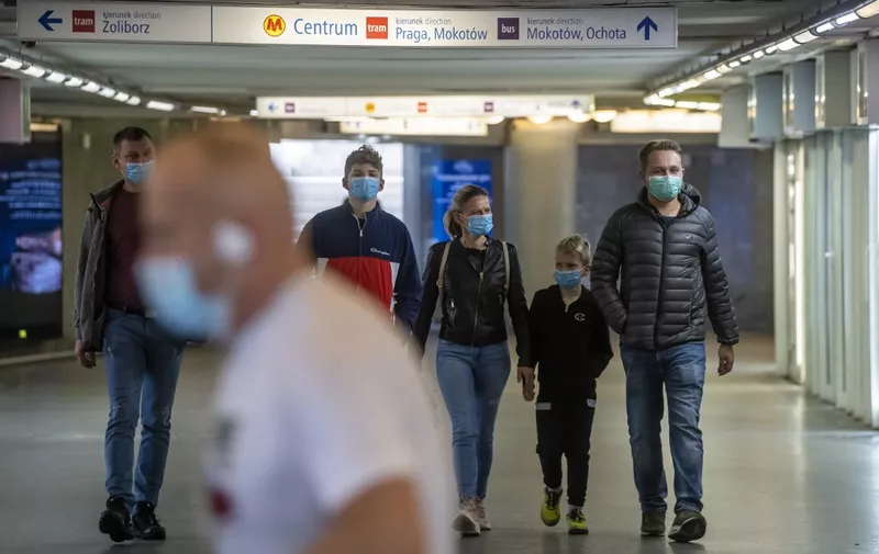 People wearing protective masks are seen on the streets of Warsaw after the Polish government tightened restrictions in the fight against the coronavirus and introduced mandatory mouth and nose coverage in public places, on October 10, 2020. - Polish senior citizens will once again be able to do their shopping without contact with the rest of the population, with shops reserved for them for two hours each day, the Polish Prime Minister announced on Saturday following record increases in contamination. (Photo by Wojtek RADWANSKI / AFP)