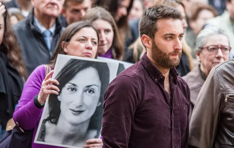 May 16, 2019 - Valletta, Malta - Matthew Galizia stands in front of a photo of his mother, the murdered journalist Daphne Caruana Galizia.  After 19 months of impunity in finding those who ordered the killing of Maltese journalist Daphne Caruana Galizia, supporters of democracy, press freedom and anti-corruption initiatives gathered at Vallettaâ€™s Great Siege Momorial for a vigil to celebrate her legacy and keep pressure on the Maltese government and international authorities.  Demonstrators held up yellow signs reading â€œinvestigate themâ€ and asking for public inquiries...Galizia was assassinated in a car bombing in October 2017 while investigating the government, including the head of state, for corruption.  At the time of her death, she had dozens of lawsuits against her designed to create a chilling effect on her work.  The lawsuits persist posthumously.,Image: 434016838, License: Rights-managed, Restrictions: , Model Release: no