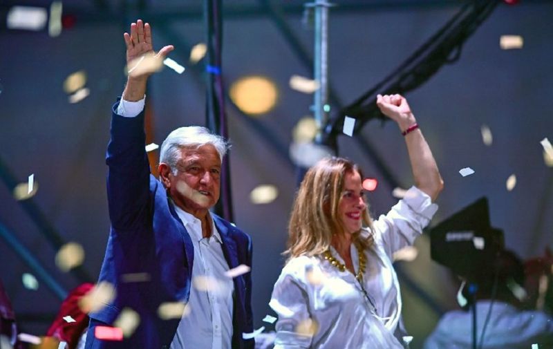 Newly elected Mexico's President Andres Manuel Lopez Obrador (L), running for "Juntos haremos historia" party, and his wife Beatriz Gutierrez Muller cheer supporters at the Zocalo Square after winning general elections, in Mexico City, on July 1, 2018. / AFP PHOTO / RONALDO SCHEMIDT