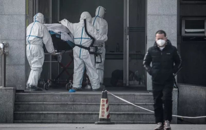 Medical staff members carry a patient into the Jinyintan hospital, where patients infected by a mysterious SARS-like virus are being treated, in Wuhan in China's central Hubei province on January 18, 2020. - The true scale of the outbreak of a mysterious SARS-like virus in China is likely far bigger than officially reported, scientists have warned, as countries ramp up measures to prevent the disease from spreading. (Photo by STR / AFP) / China OUT