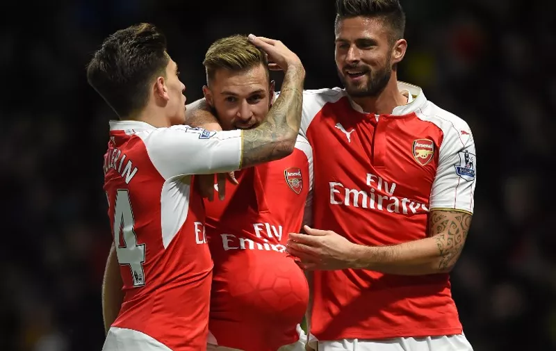 Arsenal's Welsh midfielder Aaron Ramsey (C) celebrates with Arsenal's Spanish defender Hector Bellerin and Arsenal's French striker Olivier Giroud (R) after scoring their third goal during the English Premier League football match between Watford and Arsenal at Vicarage Road Stadium in Watford, north of London on October 17, 2015. AFP PHOTO / PAUL ELLIS

RESTRICTED TO EDITORIAL USE. No use with unauthorized audio, video, data, fixture lists, club/league logos or 'live' services. Online in-match use limited to 75 images, no video emulation. No use in betting, games or single club/league/player publications.