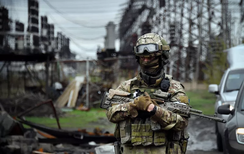 In this picture taken on April 13, 2022, a Russian soldier stands guard at the Luhansk power plant in the town of Shchastya. - *EDITOR'S NOTE: This picture was taken during a trip organized by the Russian military.* (Photo by Alexander NEMENOV / AFP)