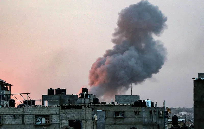 Smoke rises above buildings during an early morning Israeli strike on Rafah in the southern Gaza Strip on May 11, 2023, amid the ongoing conflict between Israel and the militant group Hamas. Israeli strikes hit Gaza on May 11 after renewed US criticism over its conduct of the war and a UN warning of "epic" disaster if an outright invasion of crowded Rafah city occurs. (Photo by AFP)