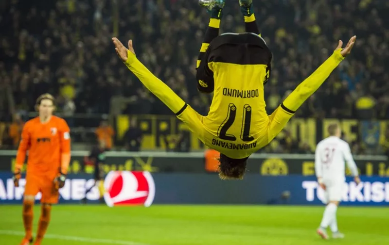 Dortmund's Gabonese midfielder Pierre-Emerick Aubameyang somersaults as he celebrates scoring his side's 5th goal to complete his hat-trick during the German first division football Bundesliga match between Borussia Dortmund and FC Augsburg on October 25, 2015 in Dortmund, western Germany. Dortmund won the match 5-1. AFP PHOTO / ODD ANDERSEN
RESTRICTIONS: DURING MATCH TIME: DFL RULES TO LIMIT THE ONLINE USAGE TO 15 PICTURES PER MATCH AND FORBID IMAGE SEQUENCES TO SIMULATE VIDEO. 
==RESTRICTED TO EDITORIAL USE ==
FOR FURTHER QUERIES PLEASE CONTACT THE DFL DIRECTLY AT + 49 69 650050.