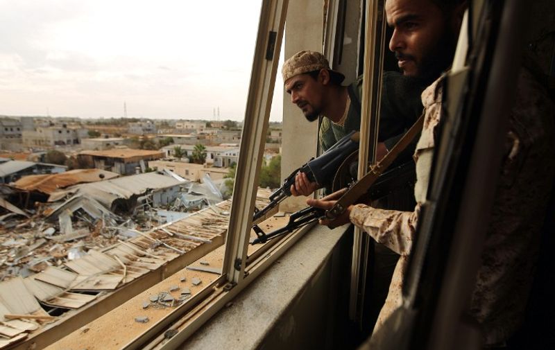 Soldiers from the Libyan National Army, led by Marshal Khalifa Haftar, check the surrounding area from inside a damaged building in the Qawarsha sector, 10 kilometres (six miles) west of the centre of Benghazi, on November 18, 2016.
The armed forces led by Marshal Khalifa Haftar announced a "great victory" against jihadist fighters in Libya's second city of Benghazi. / AFP PHOTO / Abdullah DOMA