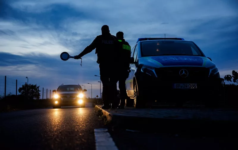 Officers of the German Federal Police (Bundespolizei) stop a car near Forst, eastern Germany on October 11, 2023, during a patrol near the border with Poland. (Photo by JENS SCHLUETER / AFP)