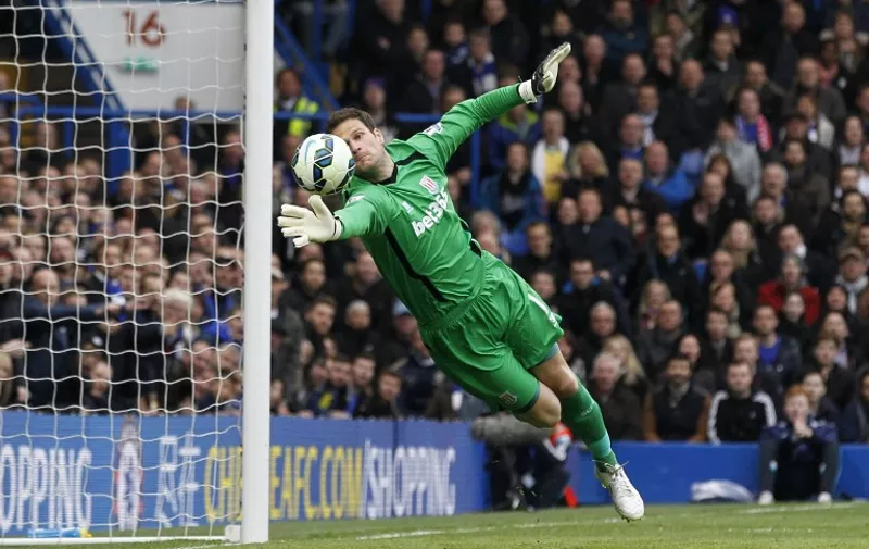 Stoke City's Bosnian goalkeeper Asmir Begovic makes a save from a deflected shot from Chelsea's French striker Loic Remy during the English Premier League football match between Chelsea and Stoke City at Stamford Bridge in London on April 4, 2015. AFP PHOTO / IAN KINGTON

RESTRICTED TO EDITORIAL USE. No use with unauthorized audio, video, data, fixture lists, club/league logos or live services. Online in-match use limited to 45 images, no video emulation. No use in betting, games or single club/league/player publications.