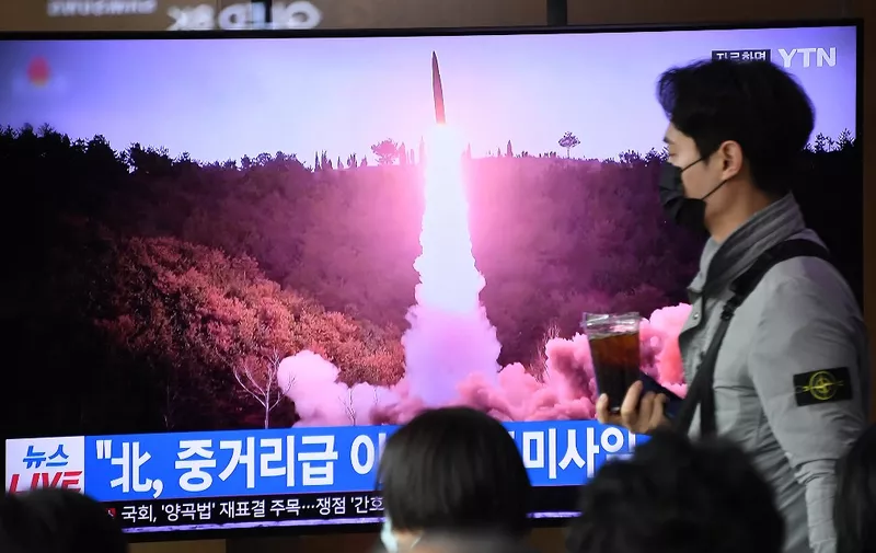 A man walks past a television screen showing a news broadcast with file footage of a North Korean missile test, at a railway station in Seoul on April 13, 2023. - North Korea fired a ballistic missile on April 13, Seoul's military said, prompting Japan to briefly issue a seek shelter warning to residents of the northern Hokkaido region. (Photo by Jung Yeon-je / AFP)