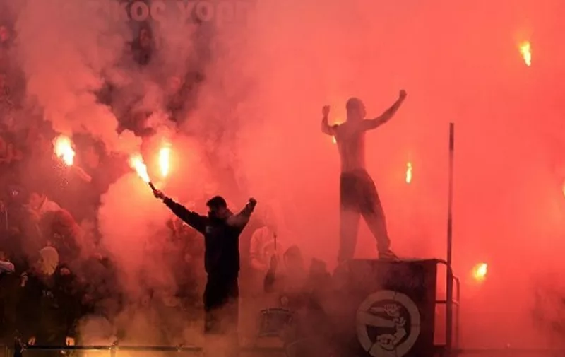 Atromitos  fans  lit flares during thei Greek league football match Atromitos vs Olympiakos Piraeus at the Atromitos stadium at Peristeri Athens western suburb on January 12, 2014 .  AFP PHOTO / ARIS MESSINIS