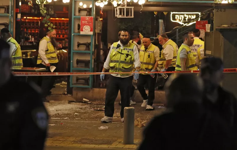 Forensics experts gather at the scene of a shooting attack in Dizengoff Street in the centre of Israel's Mediterranean coastal city of Tel Aviv on April 7, 2022. - At least two people were killed and several wounded during an attack in the Israeli city of Tel Aviv on April 7, a hospital said. It is the latest incident among a surge of violence in Israel and the West Bank since late March. (Photo by Ahmad GHARABLI / AFP)