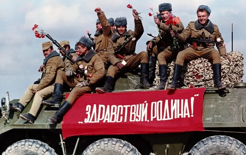 Soviet airborne regiments cross the Afghan border to USSR with a banner on the tank reading "Hello motherland", on February 6, 1989 in Termez, base of Soviet Union military operations in Afghanistan, during the Afghan Civil War, after Soviet withdrawal from Afghanistan. (Photo by Vitaly ARMAND / AFP)