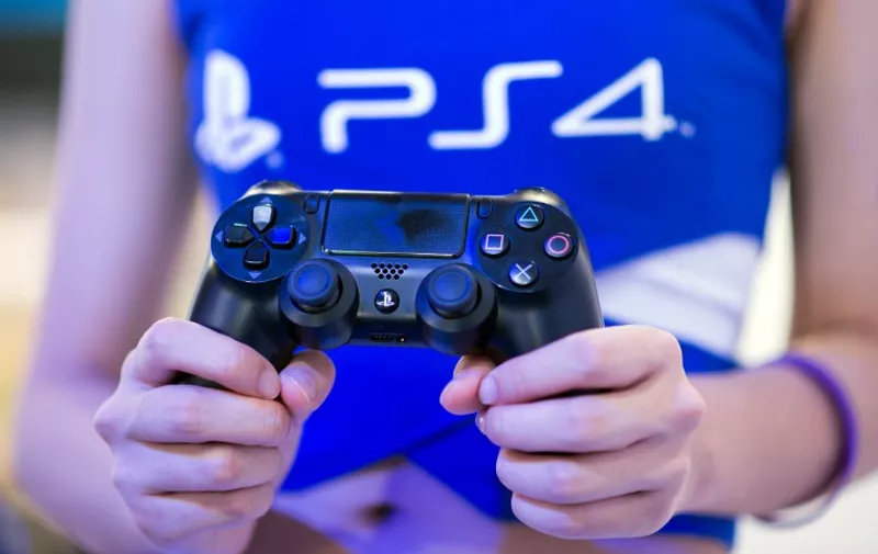 A hostess holds a remote of a  Playstation 4 at the Sony booth during the China Joy fair in Shanghai on July 31, 2014. The gamer fair China Joy (China Digital Entertainment Expo &amp; Conference) opens its doors from July 31 to August 3, 2014. Sony said on July 31 it saw a $261 million first-quarter net profit thanks to brisk sales of its PlayStation 4 console and a weak yen, but said it still expects a full-year loss.    AFP PHOTO / JOHANNES EISELE