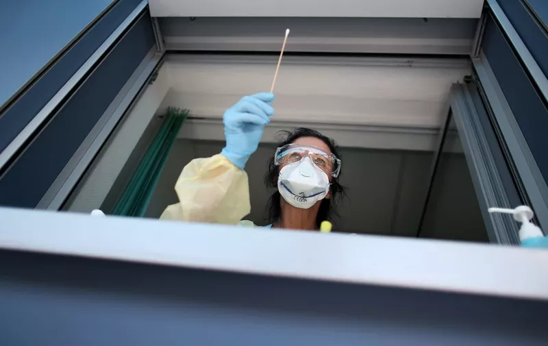 Nurse Sylke Pflugmacher takes a sample at a testing point for medical staff members at the community hospital in Magdeburg, eastern Germany, on April 16, 2020 during the novel coronavirus COVID-19 pandemic. (Photo by Ronny Hartmann / AFP)