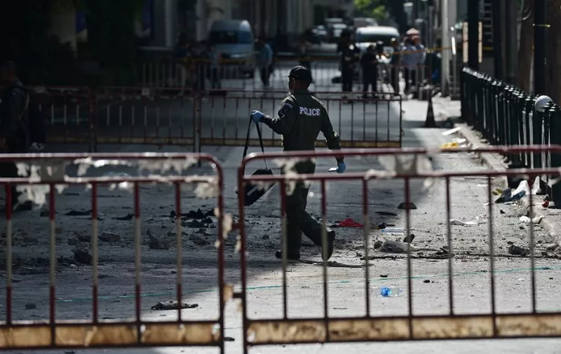 TOPSHOTS
A police officer walks at the cordoned-off site of a bomb blast outside the popular Erawan shrine in the heart of Bangkok's tourist and commercial centre on August 18, 2015.  The death toll from a bomb blast in the Thai capital rose to 21 on August 18 with 123 wounded, police said, with seven tourists from China, Hong Kong, Malaysia and Singapore among those killed in the attack.   AFP PHOTO / Christophe ARCHAMBAULT
