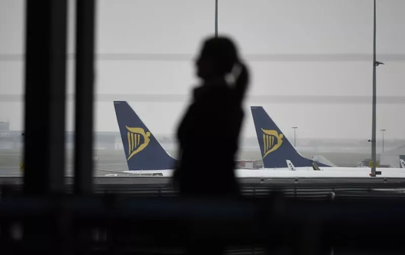 A groundstaff stands in a terminal with Ryanair planes in background during what could be the biggest strike in the airline's history, at Charleroi Airport in Gosselies on September 28 2018. - Ryanair cancelled scores of European flights on September 28, 2018 as unions staged what they warned could be the biggest strike in the airline's history.
The Dublin-based carrier has played down fears of widespread disruption but confirmed it would cancel nearly 250 flights. (Photo by JOHN THYS / AFP)