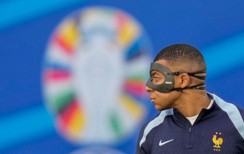 France's Kylian Mbappe with face mask looks on during the warm up before a Group D match between the Netherlands and France at the Euro 2024 soccer tournament in Leipzig, Germany, Friday, June 21, 2024. (AP Photo/Ariel Schalit)
