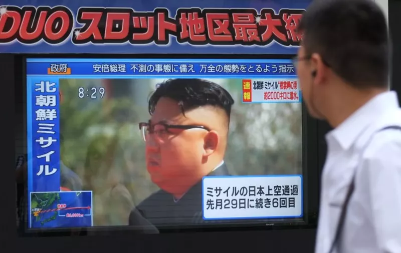 Pedestrians walk past a television screen broadcasting a news report showing North Korean leader Kim Jong-Un, in Tokyo on September 15, 2017, following a North Korean missile test that passed over Japan.
North Korea fired an intermediate range ballistic missile eastwards over Japan and into the Pacific on September 15, the US said, its latest provocation amid high tensions over its banned weapons programmes.  / AFP PHOTO / Kazuhiro NOGI