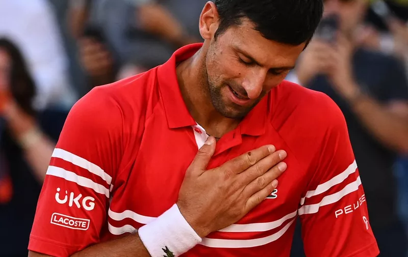 Serbia's Novak Djokovic celebrates after winning against Greece's Stefanos Tsitsipas at the end of their men's final tennis match on Day 15 of The Roland Garros 2021 French Open tennis tournament in Paris on June 13, 2021. (Photo by Anne-Christine POUJOULAT / AFP)