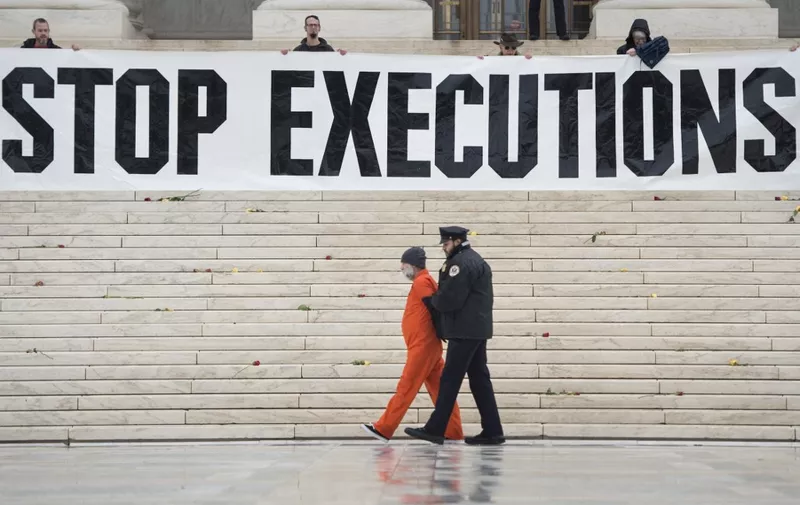 Randy Gardner is removed by police while wearing his executed brother's prison jumpsuit during an anti death penalty protest at the US Supreme Court January 17, 2017 in Washington, DC. (Photo by Brendan Smialowski / AFP)