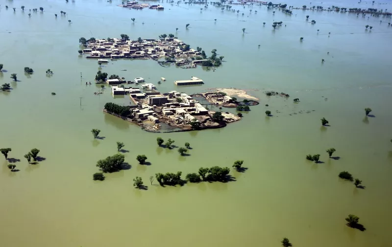This aerial photograph taken on September 1, 2022 shows a flooded residential area after heavy monsoon rains in Dadu district of Sindh province. - Army helicopters flew sorties over cut-off areas in Pakistan's mountainous north on August 31 and rescue parties fanned out across waterlogged plains in the south as misery mounted for millions trapped by the worst floods in the country's history. (Photo by Husnain ALI / AFP)