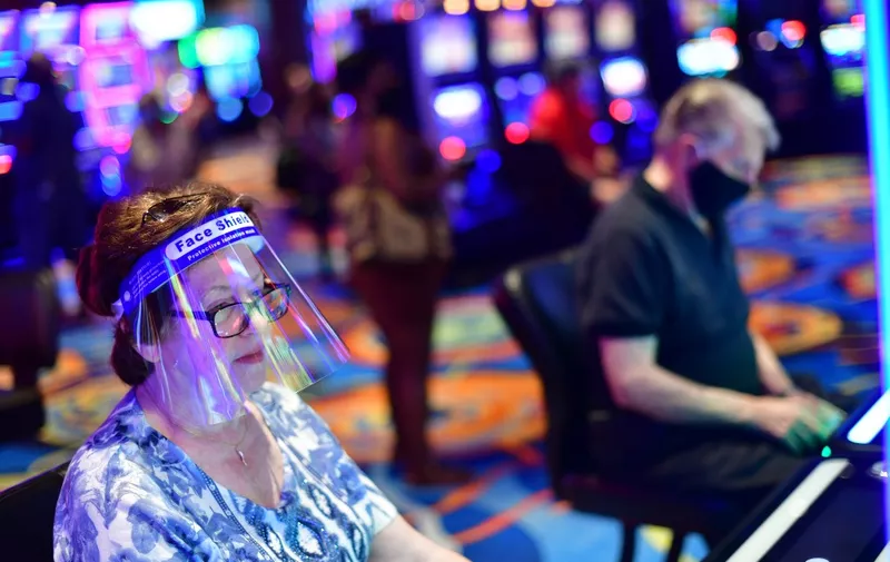 ATLANTIC CITY, NJ - JULY 03: A woman wearing a face shield gambles at Ocean Casino after it reopened on July 3, 2020 in Atlantic City, New Jersey. Atlantic City reopened eight of its nine casinos for business this week while limiting capacity to 25 percent following a nearly four-month shutdown in business due to the COVID-19 pandemic.   Mark Makela/Getty Images/AFP