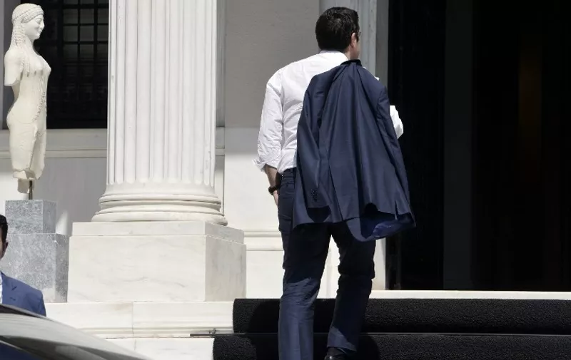 Greek Prime Minister Alexis Tsipras arrives at his office in Athens just after flying in from Brussels on July 13, 2015.  Eurozone leaders reached an agreement on plans for a bailout to prevent debt-stricken Greece from crashing out of the euro after Athens bowed to draconian demands for reform. AFP PHOTO/ LOUISA GOULIAMAKI