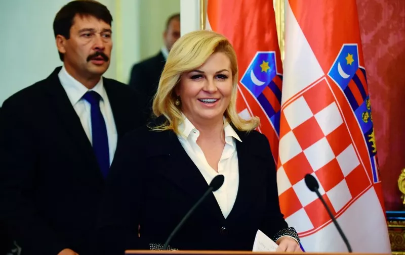 Croatian President Kolinda Grabar-Kitarovic (R) and her Hungarian counterpart Janos Ader (L) arrive for a joint press conference at the Marie Theresa Hall of the presidential palace of Buda Castle in Budapest on October 7, 2015. Kolinda Grabar-Kitarovic is on a two-day official visit to Hungary and will meet with her counterparts of Visegrads countries (Czech Republic, Hungary, Poland ans Slovakia). AFP PHOTO / ATTILA KISBENEDEK