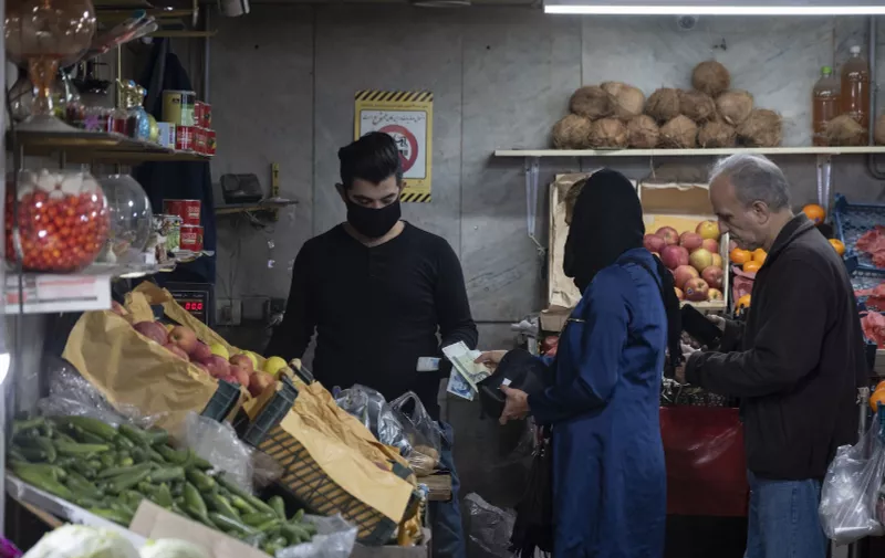 An Iranian salesman wearing a face mask receives banknotes from clients at a fruit shop in a bazaar (Market) in TehranÕs business district, following a new coronavirus disease (Covid-19) outbreak in Iran, March 28, 2020. Tehran, IRAN-3/28/2020. MORTEZA NIKOUBAZL/SIPA//NIKOUBAZL_1120.6618/2003291950/Credit:MORTEZA NIKOUBAZL/SIPA/2003291957, Image: 510628161, License: Rights-managed, Restrictions: , Model Release: no, Credit line: MORTEZA NIKOUBAZL / Sipa Press / Profimedia