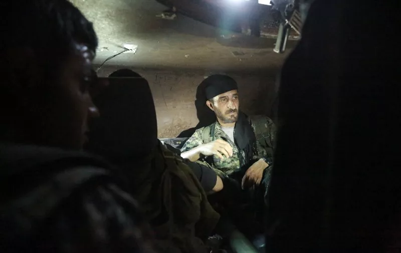 US-backed Kurdish and Arab fighters sit in a military vehicle as they advance into the Islamic State (IS) jihadist's group bastion of Manbij, in northern Syria, on June 23, 2016. 
Backed by air strikes by the US-led coalition bombing IS in Syria and Iraq, fighters with the Syrian Democratic Forces (SDF) alliance entered Manbij from the south, a monitoring group said.

 / AFP PHOTO / DELIL SOULEIMAN