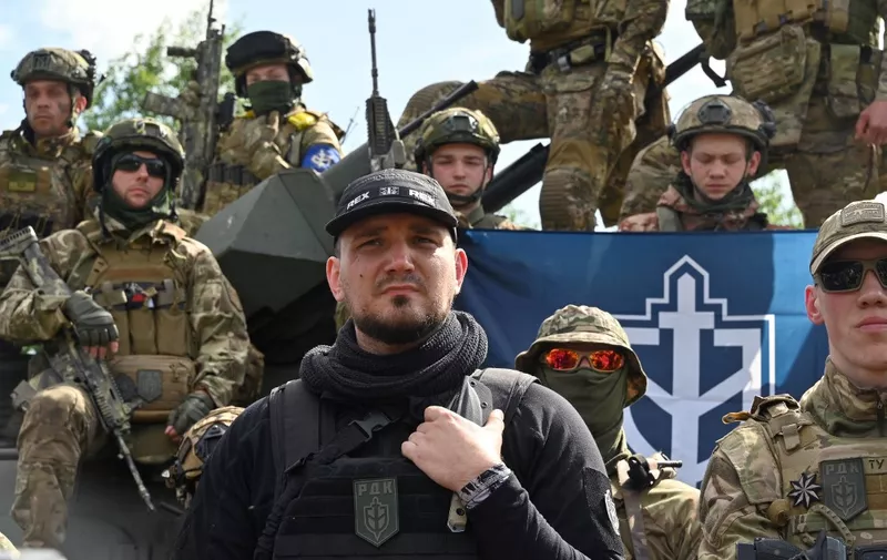 The founder of the Russian Volunteer Corps, Denis (C), known as "White Rex", flanked  by fighters in camouflage attend a presentation for the media in northern Ukraine, not far from the Russian border, on May 24, 2023, amid Russian military invasion on Ukraine. Russian nationals fighting on Ukraine's side on May 24 hailed as a "success" a brazen mission to send groups of volunteers across the border into southern Russia and back. Russia on May 23 said it deployed jets and artillery to fight off armed attackers who crossed into the southern region of Belgorod from Ukraine, exposing weaknesses on Moscow's frontier. (Photo by SERGEY BOBOK / AFP)