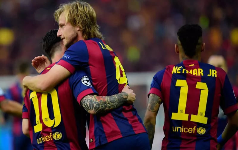 Barcelona's Croatian midfielder Ivan Rakitic (C) is congratulated by teammates after scoring during the UEFA Champions League Final football match between Juventus and FC Barcelona at the Olympic Stadium in Berlin on June 6, 2015.     AFP PHOTO / OLIVIER MORIN