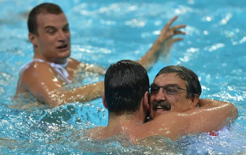 Croatia's coach Ratko Rudic (R) and players celebrate after the men's water polo gold medal match Croatia vs Italy at the London 2012 Olympic Games in London on August 12, 2012.         AFP PHOTO / KHALED DESOUKI