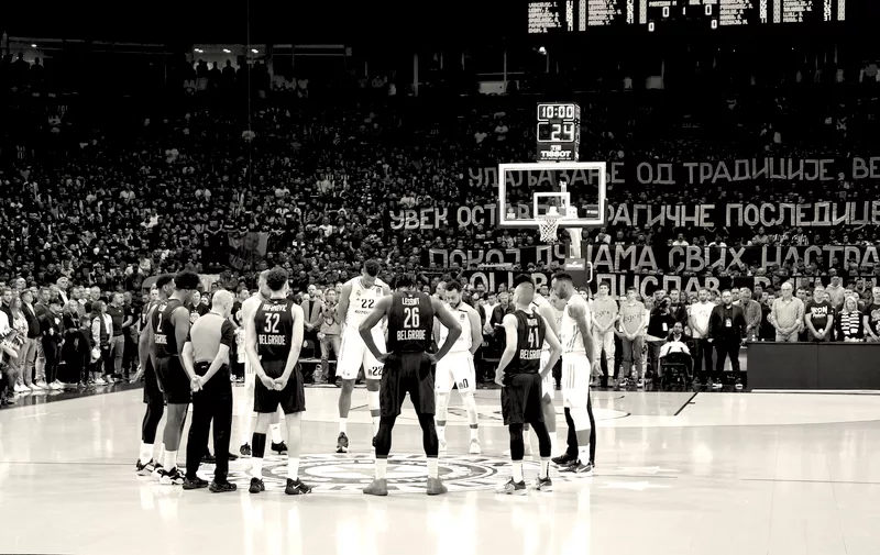 Players stand paying a minute of silence in memory of the victims of school shooting a day earlier orior the Euroleague basketball match between Partizan and Real Madrid, in Belgrade, Serbia, Thursday, May 4, 2023. A 13-year-old who opened fire Wednesday at his school in Serbia's capital. He killed eight fellow students and a guard before calling the police and being arrested. Six children and a teacher were also hospitalized. (AP Photo/Darko Vojinovic)