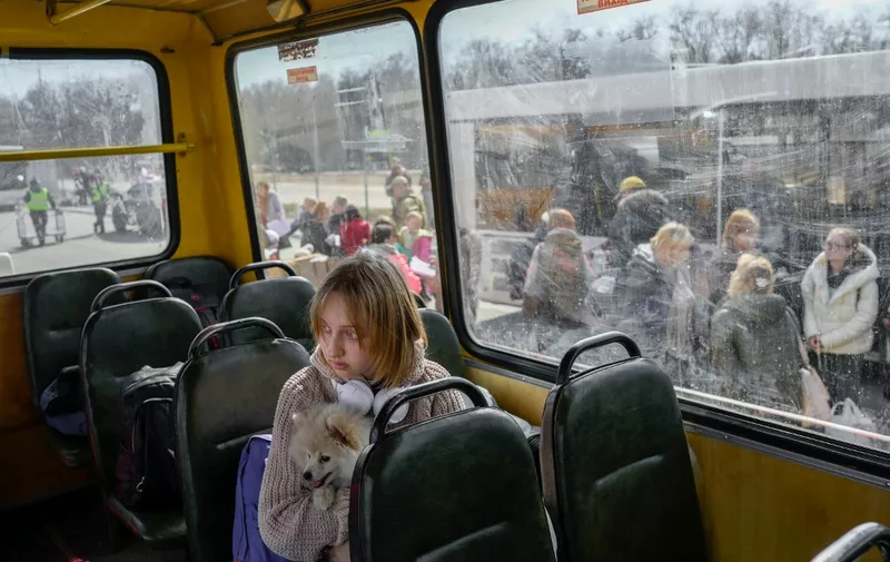 A young girl with her dog arrives at a centre for the internally displaced persons in Zaporizhzhia, some 200 kilometres (124 miles) northwest of Mariupol on April 6, 2022. - NATO chief said that, after withdrawing most of its troops from northern Ukraine, Russia aims to capture the "entire" Donbas region in the east, with the aim of creating a land corridor from Russia to annexed Crimea. (Photo by BULENT KILIC / AFP)