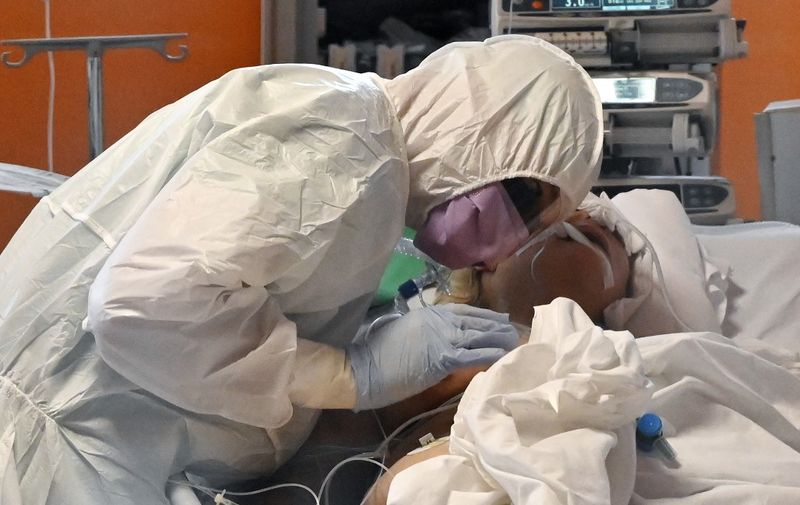 A medical worker in protective gear tends to a patient on March 24, 2020 at the new COVID 3 level intensive care unit for coronavirus COVID-19 cases at the Casal Palocco hospital near Rome, during the country's lockdown aimed at stopping the spread of the COVID-19 (new coronavirus) pandemic. (Photo by Alberto PIZZOLI / AFP)