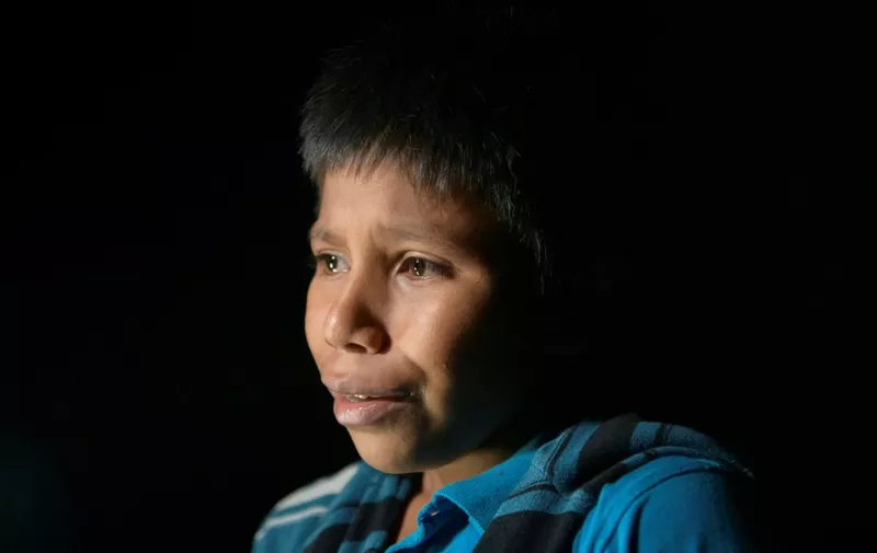 In a photo taken on March 27, 2021 unaccompanied Guatemalan child immigrant Oscar (12), who arrived illegally across the Rio Grande river from Mexico, stands after disembarking from a boat near the US border city of Roma. (Photo by Ed JONES / AFP)
