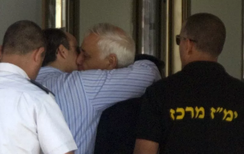 Former Israeli president Moshe Katsav (C) kisses his son as he arrives at the Maasiyahu Prison in Ramla on December 7, 2011. Katsav will begin his seven-year prison sentence after his conviction on two counts of rape, sexual harassment, indecent acts and obstruction of justice. AFP PHOTO/JACK GUEZ / AFP PHOTO / JACK GUEZ