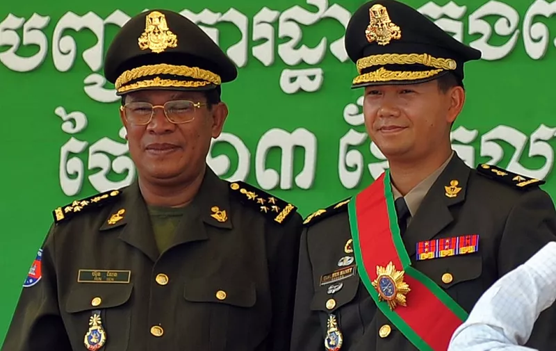 (FILES) Cambodia's Prime Minister Hun Sen (L) poses with his son Hun Manet during a ceremony at a military base in Phnom Penh on October 13, 2009. Cambodia's Prime Minister Hun Sen has for years made it clear that his eldest son Hun Manet -- a four-star general educated in the United States and Britain -- would replace him when he finally called time on nearly four decades of national leadership. (Photo by TANG CHHIN SOTHY / AFP)